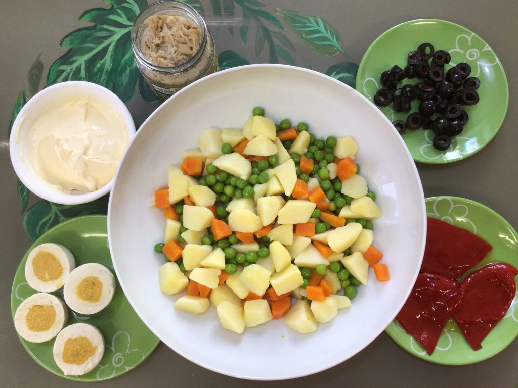 La mejor y más completa ensaladilla rusa vegana que has probado nunca. Con todo, pero sin nada animal, veganesa, atún vegano, huevos duros veganos, olivas, pimiento morrón patata, zanadoria y guisantes.