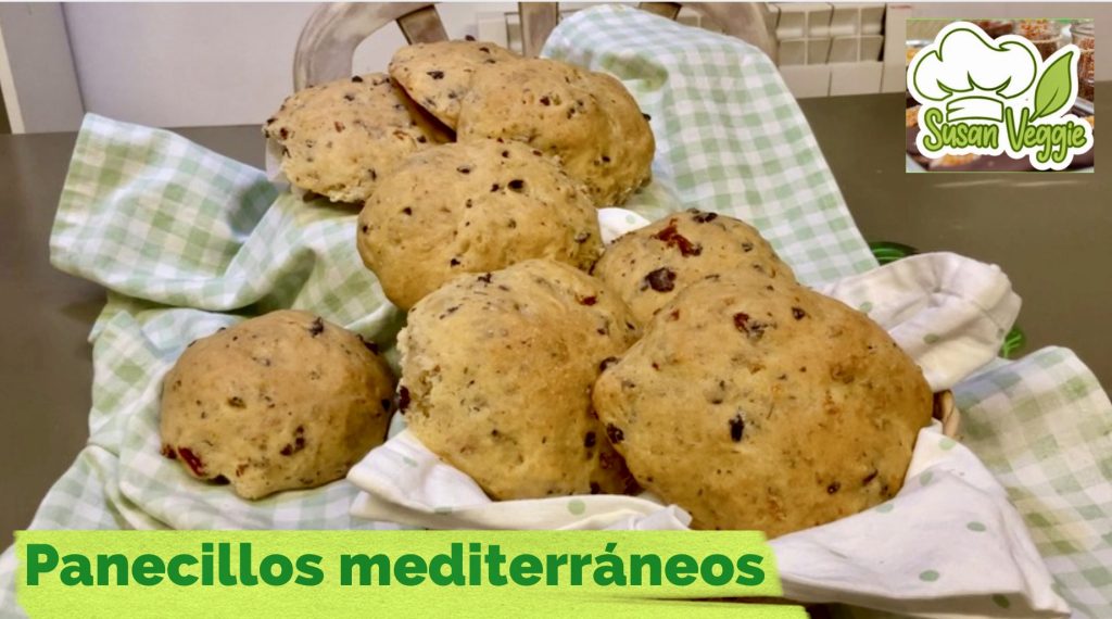 Panecillos mediterráneos sobre una mesa, se aprecia la extura tierna y los colores del tomate seco y las aceitunas que contiene la masa